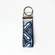 A fabric keychain strap with a navy blue and white bandana-style pattern, attached to a silver metal split ring and slider clasp, shown on a plain white background.