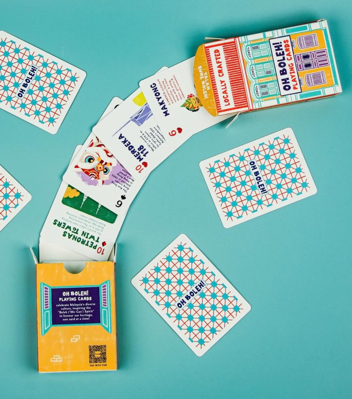 Playing cards with geometric designs and colorful packaging on a teal background