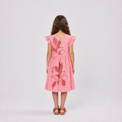 Girl standing in pink dress facing the back