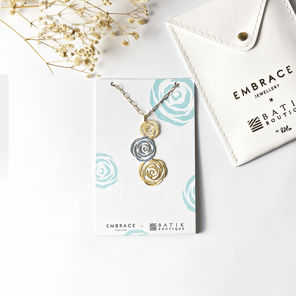 Necklace with rose-shaped pendants on a branded card with 'Embrace Batik Boutique' branding.