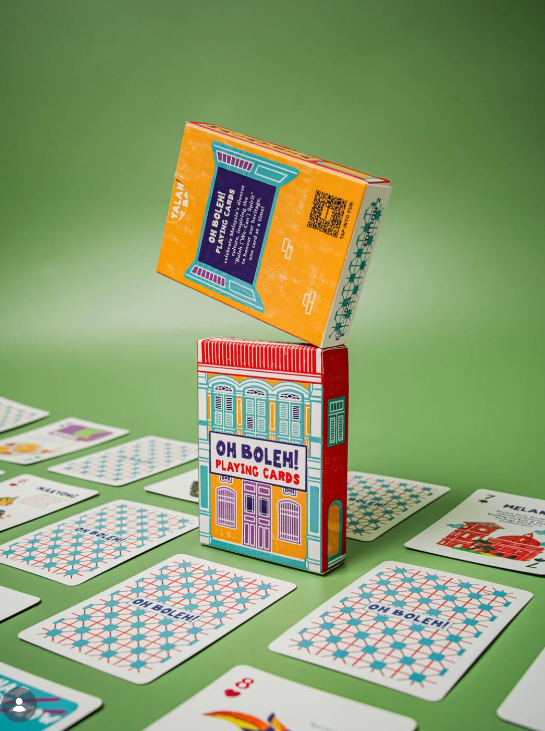 Playing cards with 'Oh Boleh!' branding on a green surface