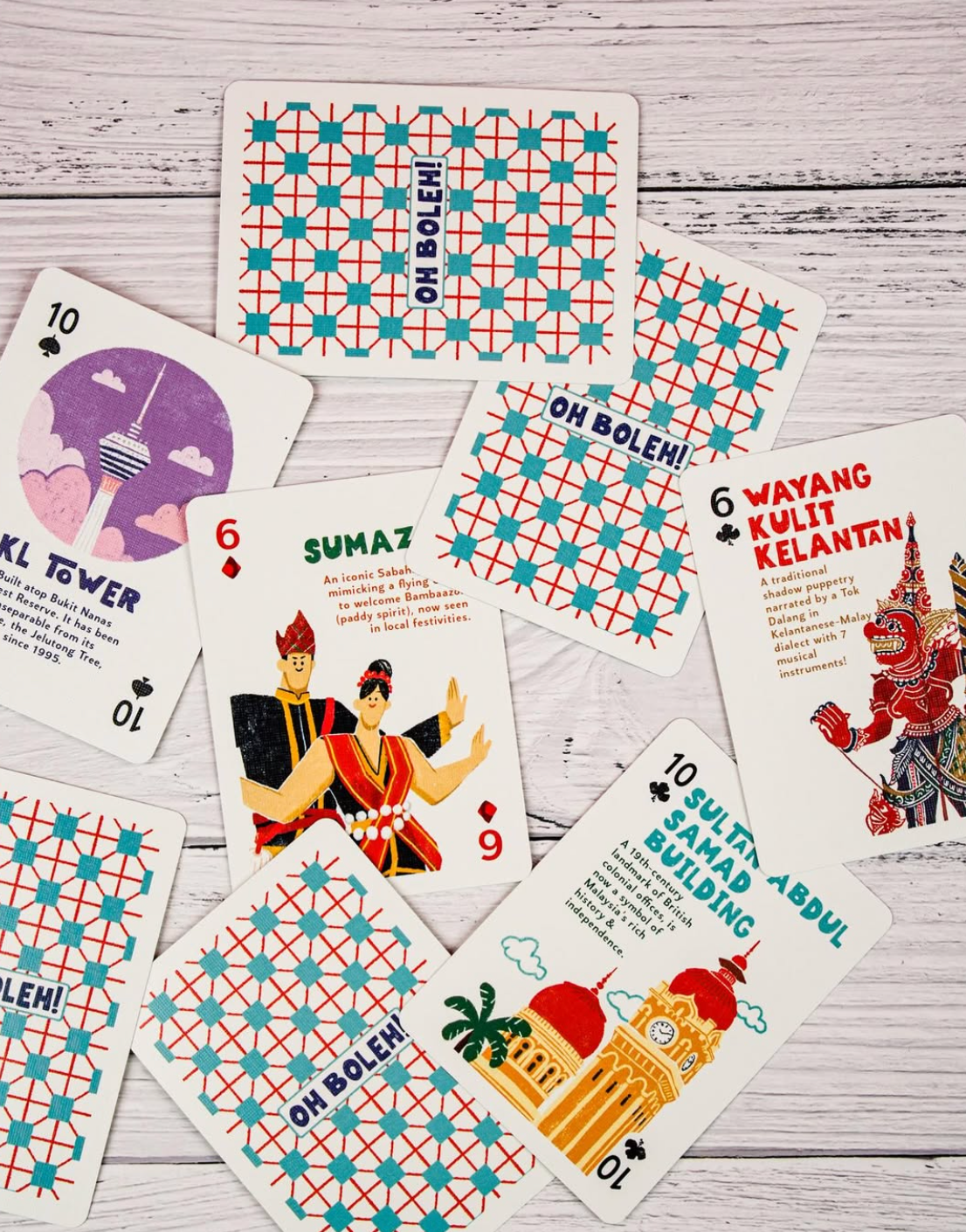 Collection of playing cards with colorful designs and text on a wooden surface