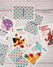 Collection of playing cards with colorful designs and text on a wooden surface