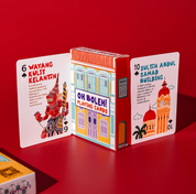 Playing card set with colorful box featuring architectural designs on a red background