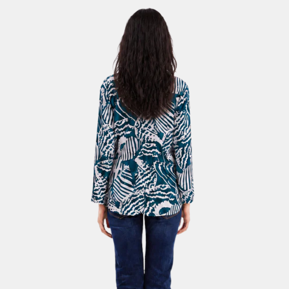 Woman wearing blue printed batik kebaya top, facing the back, showing the features of the backside of the top