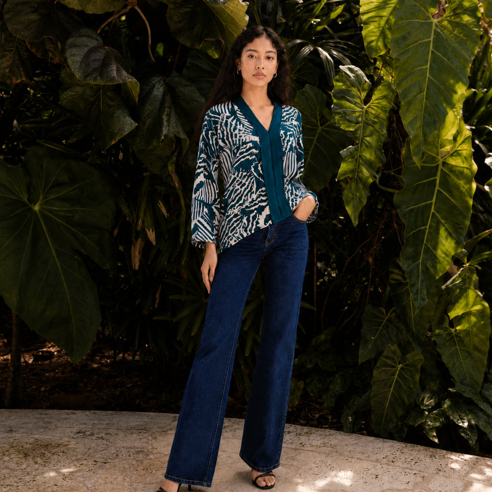 Woman wearing a Blue Printed Kebaya Top standing outdoors with trees