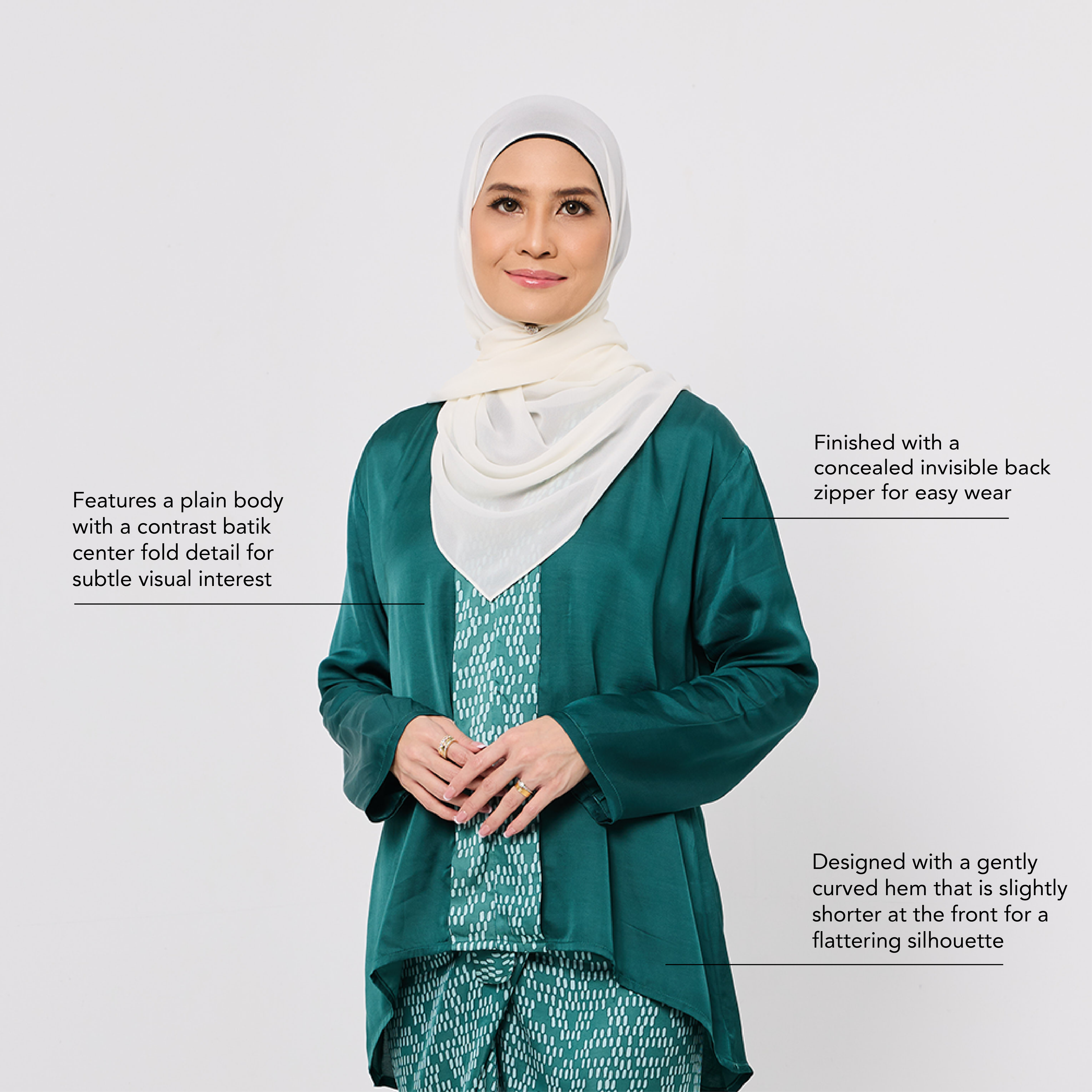 Woman wearing a green outfit with a white hijab on a light gray background
