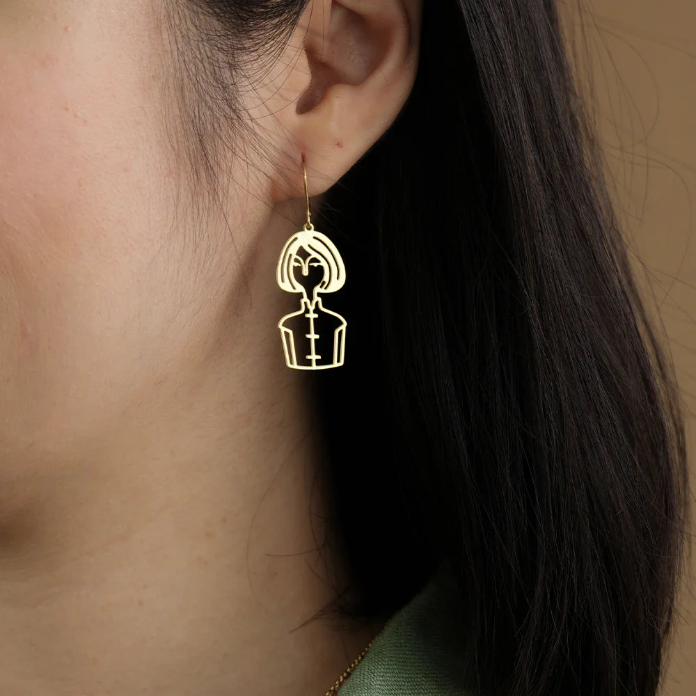 Earring with a unique design worn by a person with long dark hair.