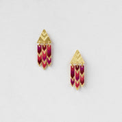 Pair of earrings with gold and pink design on a light gray background
