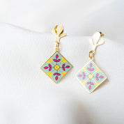 Pair of square-shaped earrings with floral design on a white background
