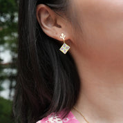 Close-up of an ear wearing a colorful earring with a blurred background