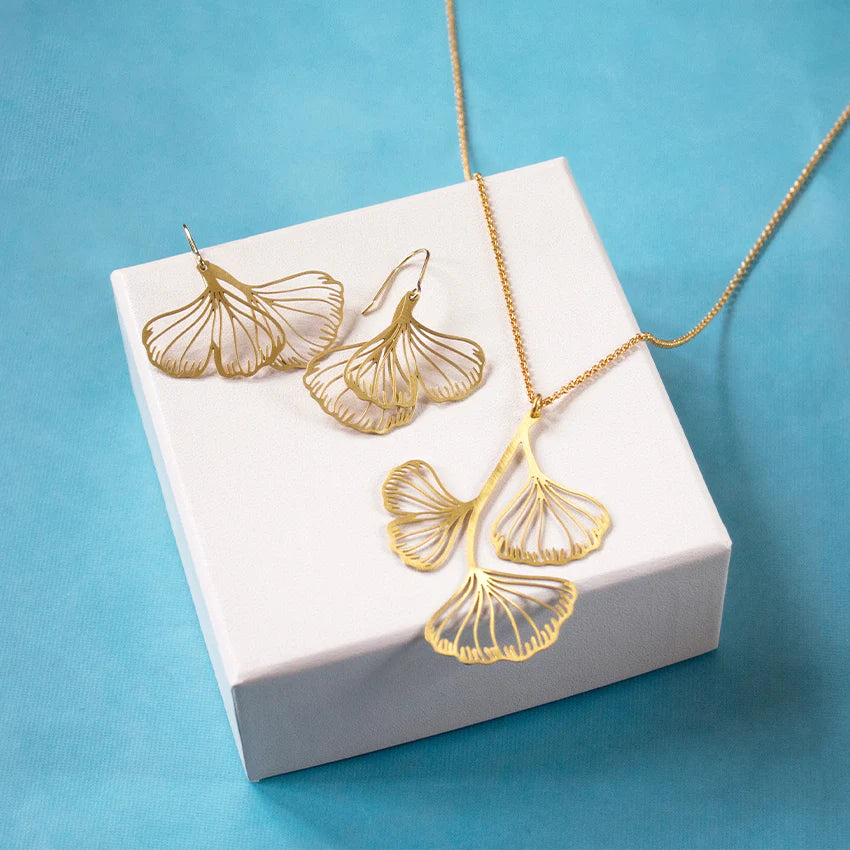 gold platterd earring beside the gold ginko necklace 