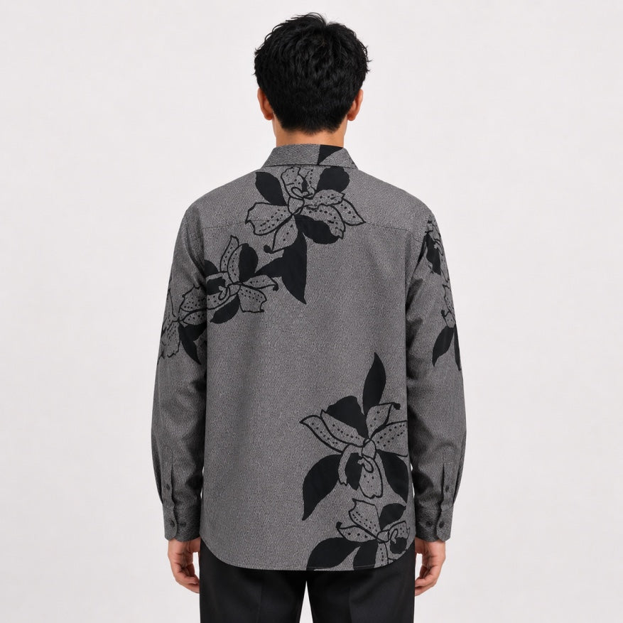 Person wearing a gray floral patterned shirt on a white background